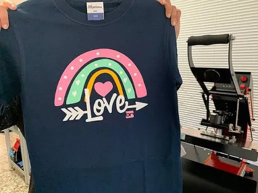 Polera estampada con diseño personalizado junto a la máquina de estampado